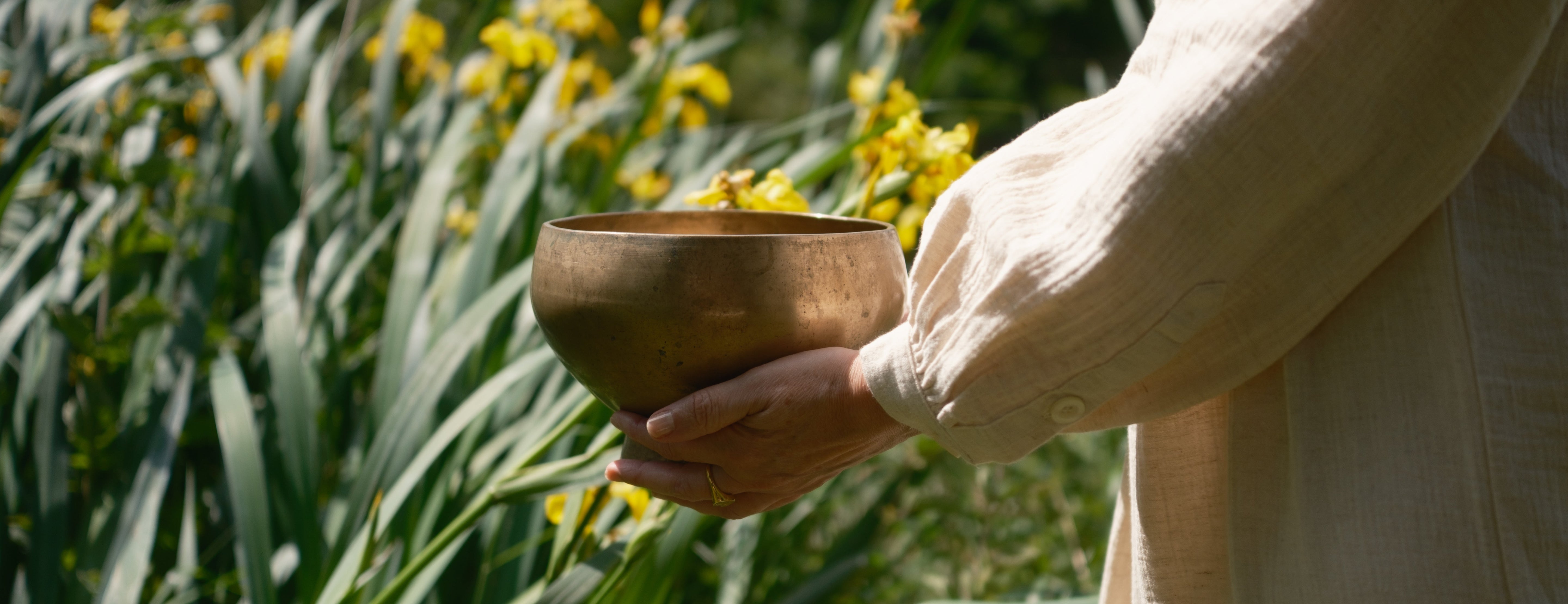Antique singing bowl being hold by woman in a park
