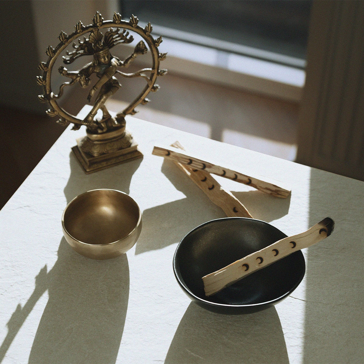 burning palosanto aroma stick infront of a nataraja statue and singing bowl