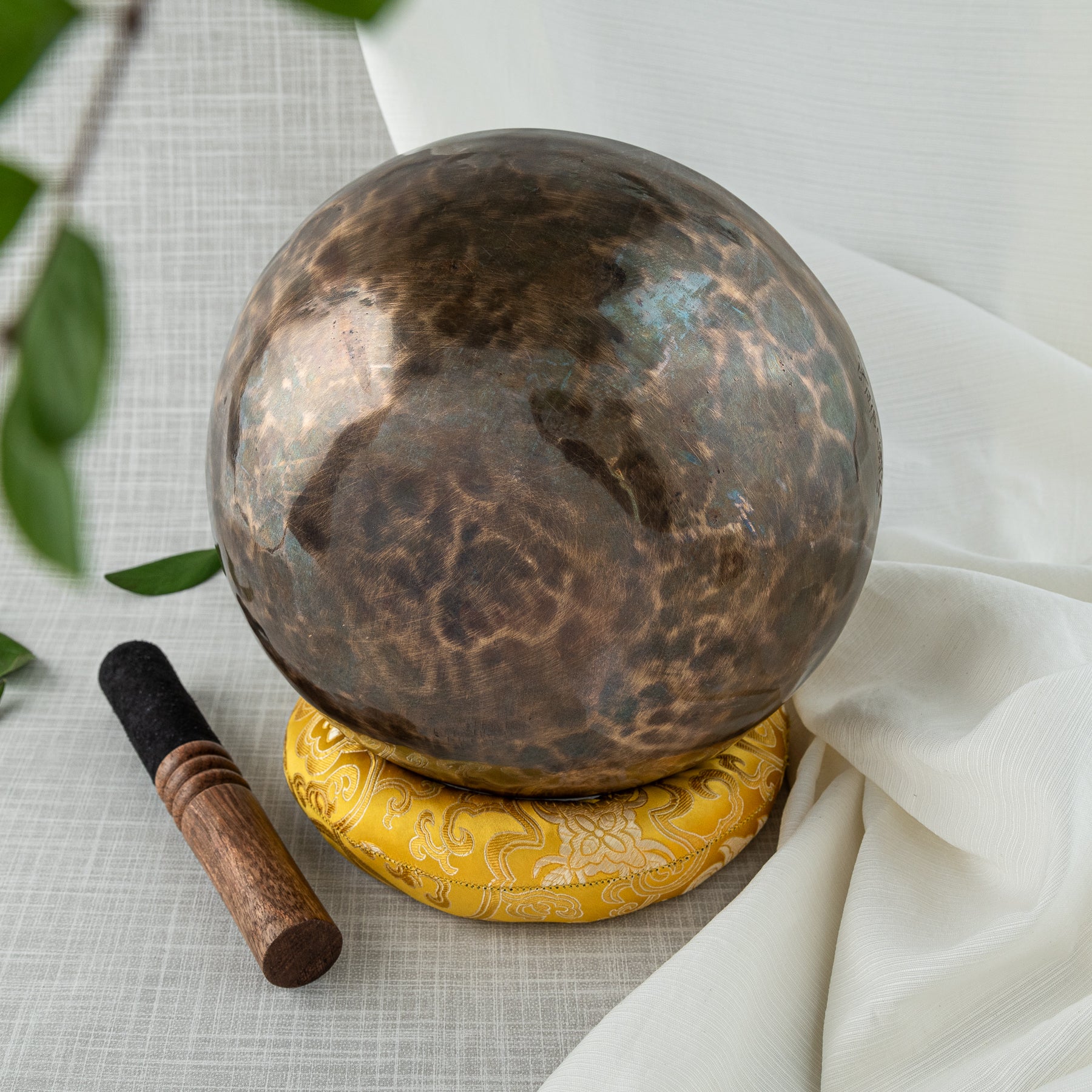 Bottom of singing bowl on yellow pillow