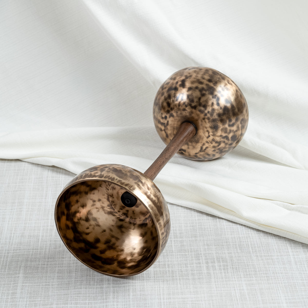 Side view of double sided singing bowl in handle