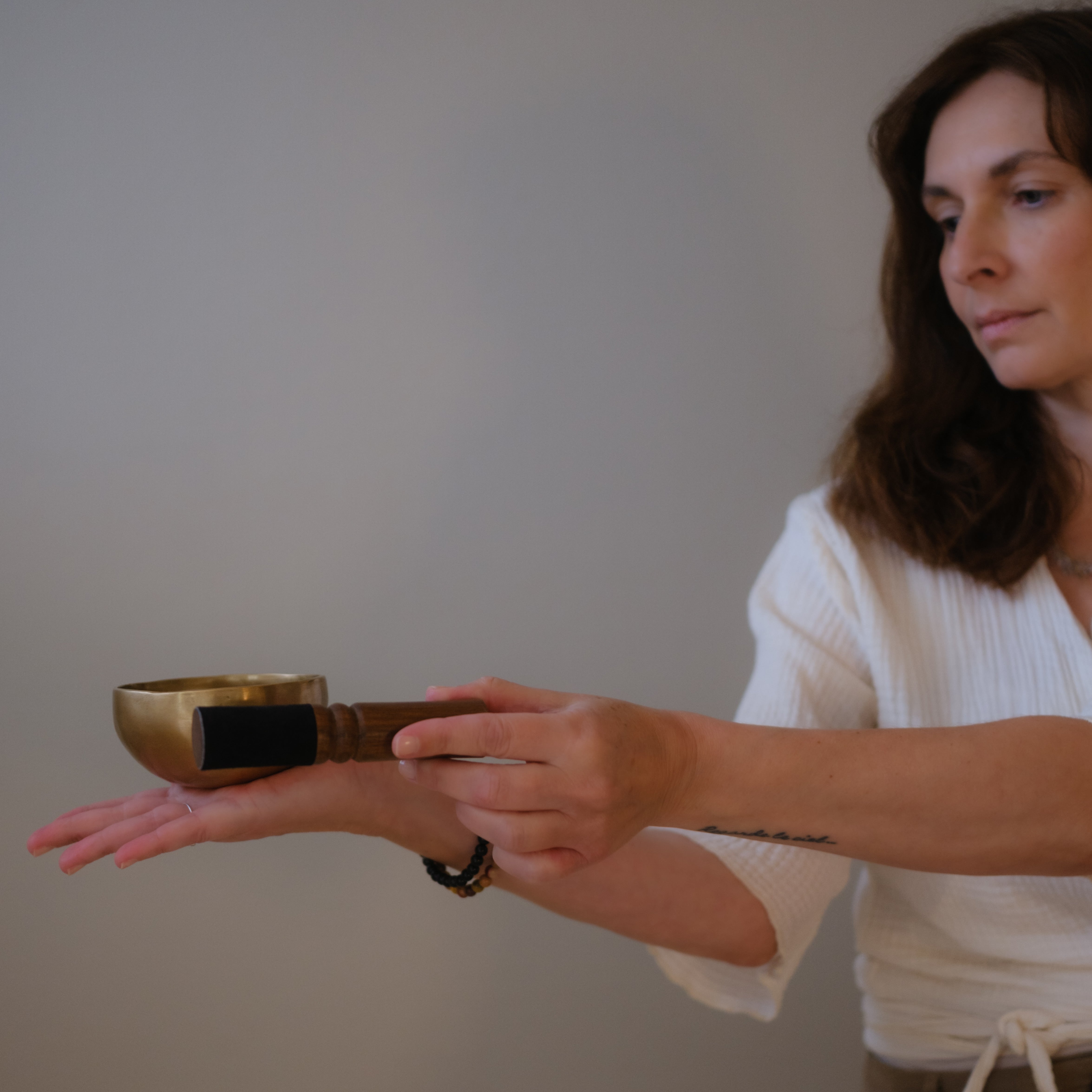 Model holding small dim singing bowl