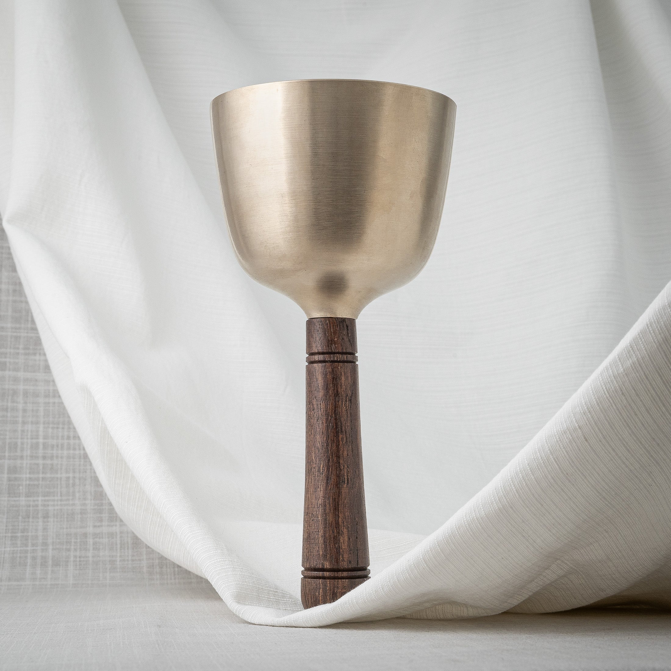 Singing bowl with wooden handle in upright position